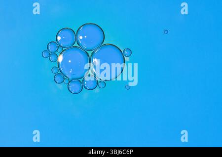 Makroaufnahme der Wasser-Öl-Emulsion über farbigem Hintergrund Stockfoto