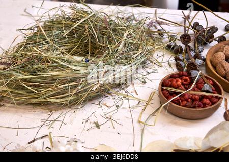 Flache Zusammensetzung mit natürlichen Materialien für die Herstellung eines getrockneten Blumenkranzes. Einschließlich getrocknete Blumen, Gräser, Garn, Schere, Blumendraht, Stockfoto