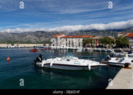 Boote im Hafen von Vinjerac mit dem Velebit-Gebirge im Hintergrund, Provinz Zadar, Kroatien, September 2024. Stockfoto