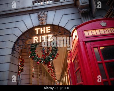 Das Ritz Hotel LONDON Weihnachtskranz dekoriert Piccadilly Christmas mit traditionellen, funktionierenden roten Telefonboxen im Vordergrund Londons, Großbritannien Stockfoto