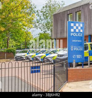 Vorderansicht der Polizeistation Droitwich in Worcestershire (West Mercia Police Force) mit fünf Polizeifahrzeugen, die vor dem Gebäude geparkt sind. Stockfoto