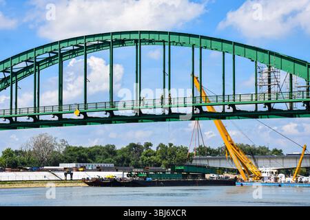Detailansicht von Arbeitern, die eine alte grüne Stahlbahnbrücke im Rahmen eines historischen Ingenieurprojekts dekonstruieren. Detailansicht der Arbeiter-Dekonstruktion Stockfoto