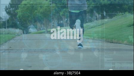Männer mit Leggings und Turnschuhen auf einem Betonparkweg mit Grasbänken und HUD-Daten Stockfoto