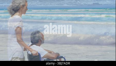 Seniorenpaar in weißen Spitzen, am Sandstrand mit Blick auf das Meer, Kopierraum Stockfoto