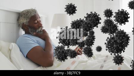 Liegender Mann in blauem T-Shirt, der Smartphone an der Nachttischlampe mit schwimmenden Virusmodellen hält Stockfoto