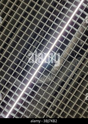 LED-Streifenlicht an einer dekorativen abgehängten Decke in Form eines Gitters, diagonale Zusammensetzung. Stockfoto