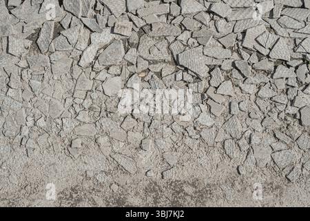In Asche gelöschte Schieferfragmente werden auf die Straße geworfen. Asbestkarzinogener Schiefer. Nahaufnahme, strukturiert. Stockfoto