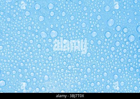 Wassertropfen auf blauer Oberfläche. Frische und sauberer Texturhintergrund. Stock Foto. Stockfoto