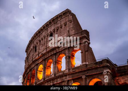 Die obere Ecke des römischen Kolosseums in Rom, Italien, erhebt sich vor dem Hintergrund eines stimmungsvollen Himmels und dramatischer Wolken und fängt zeitlose Kraft ein. Stockfoto