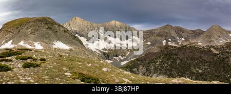 Dieses Panorama zeigt Colorado Sangre de Cristo 14ers Blanca Peak und Ellingwood Point, beleuchtet durch sanftes Licht gegen kontrastierende dunkle Wolken. Stockfoto