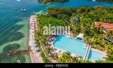 Atemberaubender Blick aus der Vogelperspektive auf einen Resort-Pool, umgeben von üppigem Grün und malerischem Wasser auf den Rosario-Inseln in der Nähe von Cartagena, Kolumbien. Stockfoto