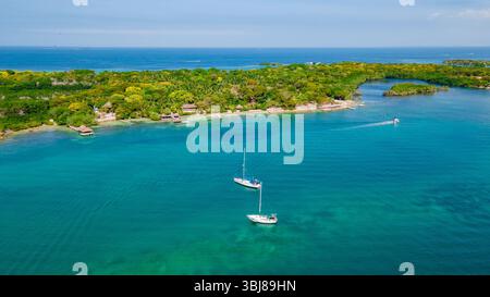 Blick aus der Vogelperspektive auf die atemberaubenden Rosario-Inseln mit türkisfarbenem Wasser, üppigem Grün und Booten, die im wunderschönen Cartagena, Kolumbien, segeln. Stockfoto
