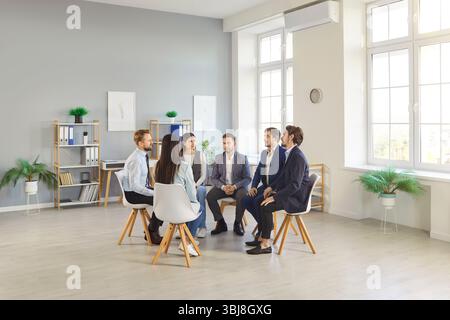 Verschiedene Gruppen von Kollegen treffen und sprechen in Einem Kreis im Büro Stockfoto