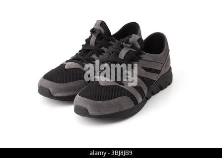 Stylische Sneakers in Schwarz und Grau auf weißem Hintergrund. Sportschuhe für Sport-, Spazier- oder Freizeitkleidung Stockfoto