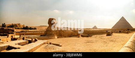 Panoramablick auf die Sphinx und Pyramiden in Gizeh, Ägypten, mit goldenem Sand und antiken Ruinen, die sich bis zum Horizont erstrecken. Stockfoto