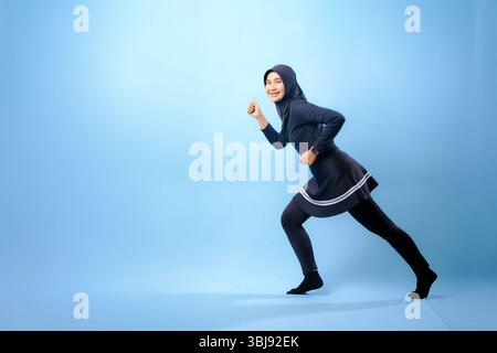Eine Frau in schwarz-weißem Outfit rennt. Konzept der Entschlossenheit und Konzentration, während die Frau sich dazu drängt, schneller zu laufen Stockfoto