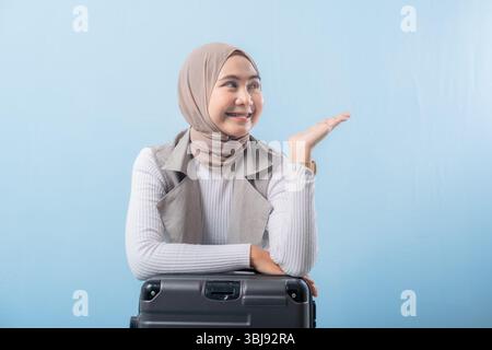 Eine Frau, die einen Schal trägt und auf etwas zeigt. Sie lächelt und ist glücklich Stockfoto