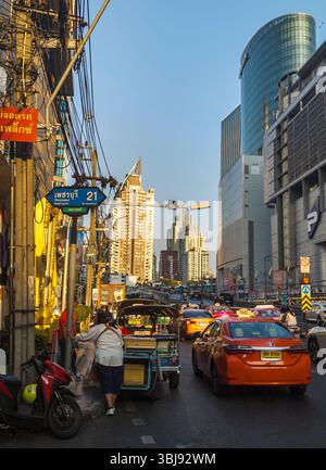 Bangkok, Thailand-07. April 2024-später Nachmittag, Sonnenlicht aus niedrigem Winkel reflektiert zufällig auf Hochhäuser und stark frequentierten Verkehr darunter während der Hauptverkehrszeit. Stockfoto
