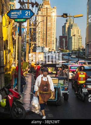 Bangkok, Thailand-07. April 2024-später Nachmittag, Sonnenlicht aus niedrigem Winkel reflektiert zufällig auf Hochhäuser und stark frequentierten Verkehr darunter während der Hauptverkehrszeit. Stockfoto