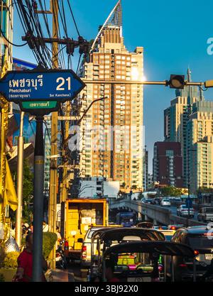 Bangkok, Thailand-07. April 2024-später Nachmittag, Sonnenlicht aus niedrigem Winkel reflektiert zufällig auf Hochhäuser und stark frequentierten Verkehr darunter während der Hauptverkehrszeit. Stockfoto
