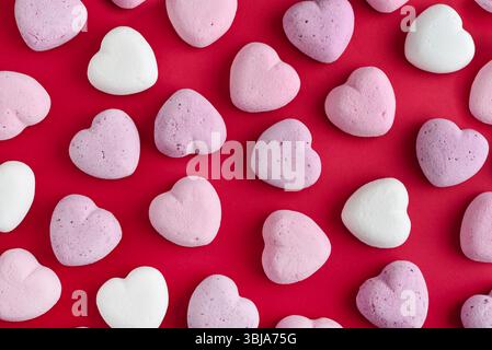 Mehrfarbige Herzmarshmallows auf rotem Hintergrund, Draufsicht, Valentinstag-Konzept. Stockfoto
