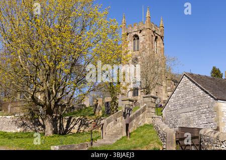 St Giles Church, Hartington Village im Frühjahr, Peak District UK. Blauer Himmel und Sonnenschein; Peak District Derbyshire UK Stockfoto