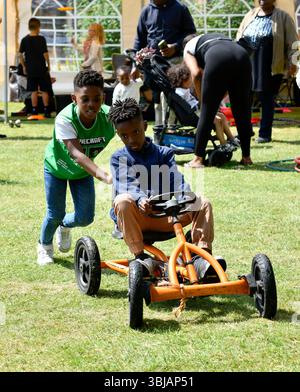 Jungs, die mit Spielzeug spielen, gehen auf den Wagen in Großbritannien. Stockfoto