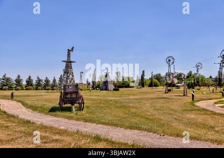 Etzikom, Alberta - 30. Juni 2021: Rustikale Windmühlen und antike Landwirtschaftsgeräte im ländlichen Etzikom, Alberta Stockfoto