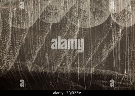 Yachtrumpf an der Wasserlinie, mit Spuren von Salz, getrocknetem Wasser und Kratzern, in Schwarz und weiß. Schwarzweiß, abstraktes Bild. Stockfoto