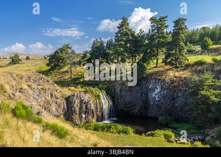 Malerischer Blick auf einen Wasserfall, der über eine felsige Klippe fließt, in der französischen Landschaft von Creuse, Nouvelle Aquitaine, in der Nähe der Stadt Saint Sulpice les Cham Stockfoto