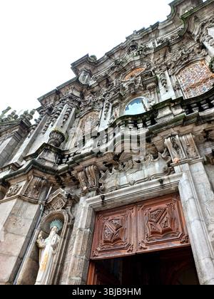 Porto, Portugal. März 30 2024 Detailansicht der reich verzierten Barockfassade von Igreja dos Clérigos mit verzierten Mauerwerken, Holztüren und Stockfoto