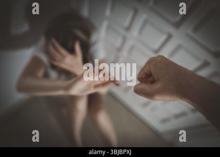 Mann schlaegt die Frau mit der Faust. Opfer von häuslicher Gewalt Stockfoto