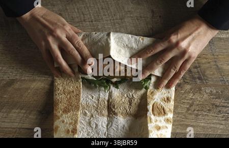 Schawarma in Lavash mit Huhn und Gemüse einwickeln Stockfoto