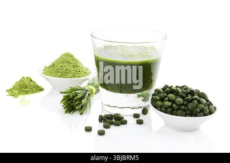Grüne Nahrungsergänzung. Spirulina, Chlorella und Weizengras. Grüner Saft, grüne Pillen, Weizengrasklingen und gemahlenes Pulver isoliert auf weißem Hintergrund Stockfoto