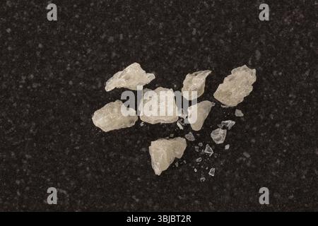 MDMA-Kristalle von oben auf schwarzem Tisch Stockfoto