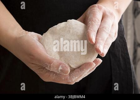 Teig in den Händen des Küchenchefs. Brotzubereitung Stockfoto