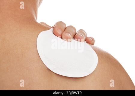 Medizinische Patch-Therapie zur Schmerzlinderung bei einem Berufskrankheiten-Syndrom eines jungen Mannes mit Schulterschmerzen. Gesundheitliche Probleme durch die überarbeiteten Nachteile Stockfoto
