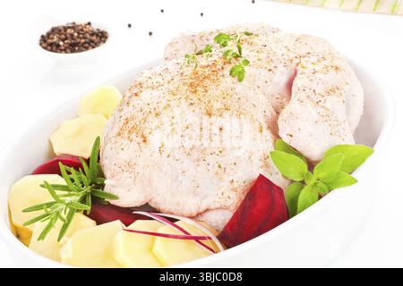Rohes Hühnchen mit frischem Gemüse und Kräutern in Backform zum Backen vorbereitet Stockfoto