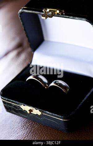 Goldene Hochzeit Ringe in luxuriösen Box auf braunem Hintergrund Stockfoto