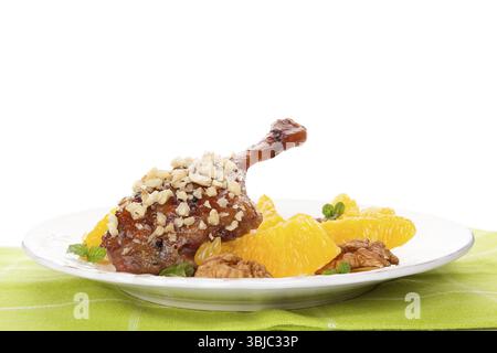 Kulinarische gebratene Ente mit Orangen und Nüssen auf Teller isoliert auf weißem Hintergrund. Köstliches festliches Essen Stockfoto