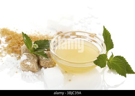 Verschiedene Arten von Süßungsmitteln - brauner Zucker, Weißzucker, Kristallzucker, künstlicher Süßstoff, Rohrzucker, Puderzucker, Honig in einer Glasschale. Isoliert Stockfoto