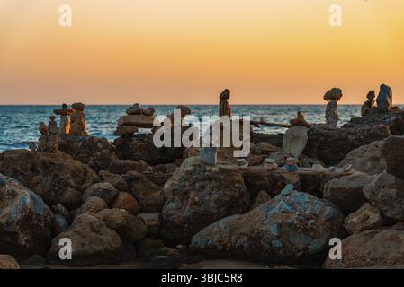 Viele ZEN-Steine am Strand bei Sonnenuntergang Stockfoto