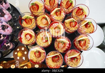 Erdbeerjoghurt im Glas mit Schokolade auf einem Banketttisch Stockfoto