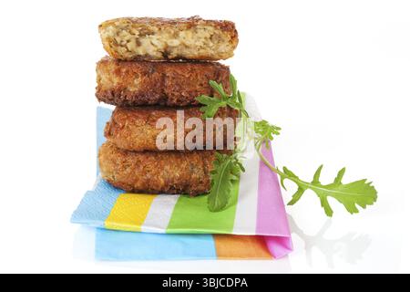 Köstlicher Falafelpastenstapel auf farbenfroher Serviette mit frischen Kräutern. Kulinarisches, luxuriöses vegetarisches Essen Stockfoto