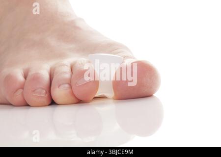 Bunion, Hallux valgus. Silikon-Finger-Zehentrenner an Füßen isoliert auf weißem Hintergrund Stockfoto