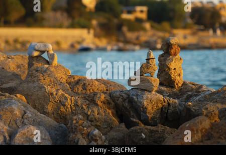 Viele ZEN-Steine am Strand bei Sonnenuntergang Stockfoto