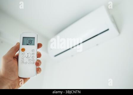 Fernbedienung mit Handgriff, die auf die Klimaanlage gerichtet ist Stockfoto
