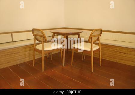 Holzstühle und Tisch in der Ecke eines stilvollen Caféraumes mit gemütlicher Einrichtung Stockfoto