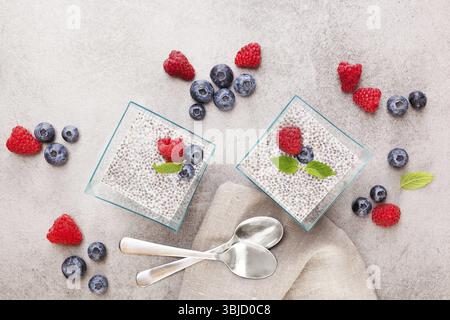 Gesunde Chiasamenpudding mit frischen Beeren und Löffeln von oben Stockfoto
