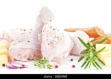 Rohe Hähnchenschenkel mit frischem Gemüse nah oben isoliert auf weißem Hintergrund Stockfoto